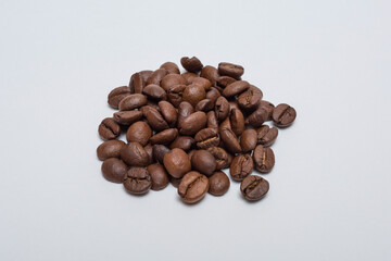 Roasted coffee beans on a white background.	