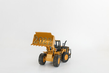 Concept Happy new year 2022,In bucket of Wheel loader   on white background