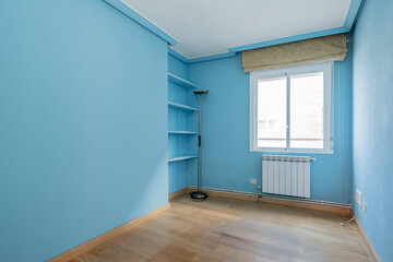 bedroom with plasterboard bookshelf and garish blue walls