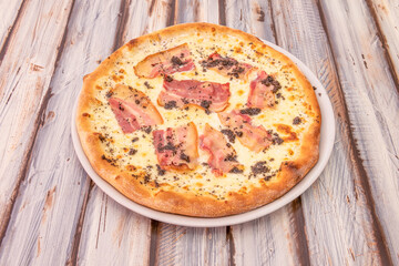 Pizza with lots of fried sliced bacon and truffle with mozzarella cheese and olive oil