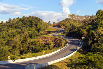 Curve road No. 3, or sky road on Root 1081 over top of mountains with green jungle in Santisuk - Bo Kluea District. Beautiful landscape scenic of road number three at Nan, Thailand.