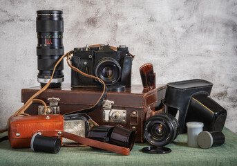 Old film cameras, photographic film, leather cases for photographic equipment. Old photographic equipment. Film photography nastalgia.