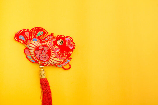 Lunar New Year decoration with lucky gold bar, lucky sacks, and red fish isolated on yellow . Tet Holiday.Translation of text appear in image: fortune good luck	