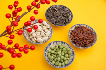 Tet Holiday, Lunar new year, chinese new year concept . Dried sunflower, lotus, watermelon and pumkin seeds top view isolated on yellow. Tet snacks