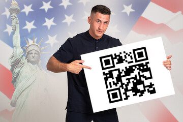 QR code in hands of man. American man demonstrates barcode. Guy in front of USA flag. Man points...