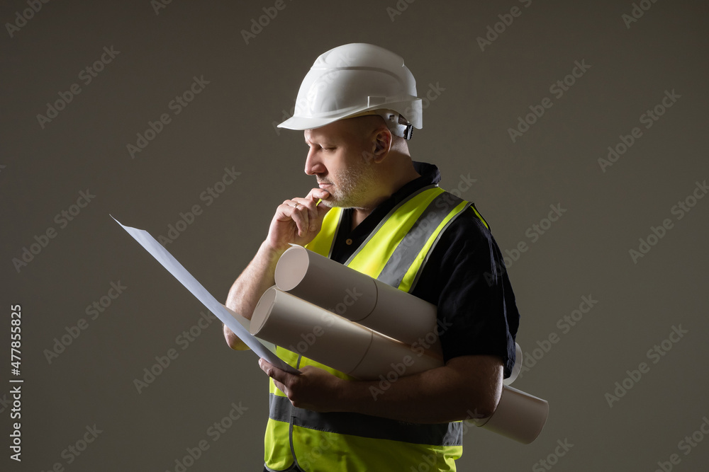 Poster portrait engineer-architect with blueprints in his hands. architect in construction uniform. constru