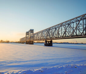 automobile and railway big iron bridge over the frozen Severnaya Dvina River