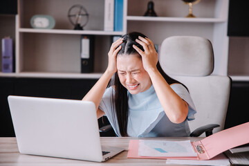 The boss is sitting at his desk showing stress from the company's problems.