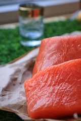 Red fish on the table, a slice of fish, seafood and alcohol, green lawn, salted fish