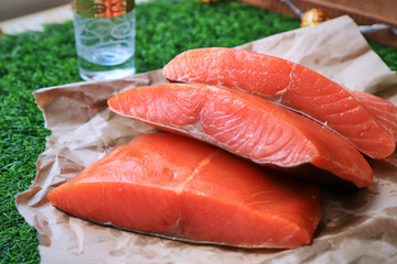 Red fish on the table, a slice of fish, seafood and alcohol, green lawn, salted fish