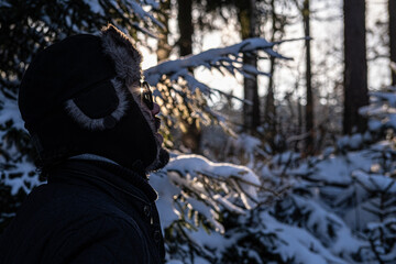 Man in the forest looking at a horizon in winter 