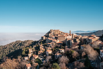 Fototapeta na wymiar Mist hanging in the valley behind the ancient mountain village of Speloncato in the Balagne region of Corsica
