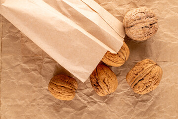 Several organic walnuts on craft paper, close-up, top view.