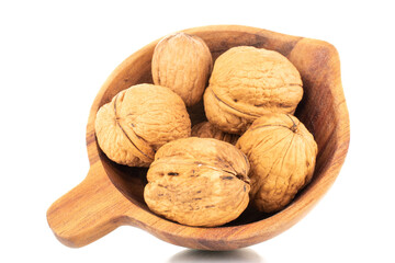 Several ripe delicious walnuts with a wooden dish, close-up, isolated on white.