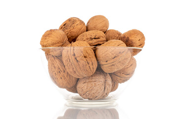 Several ripe delicious walnuts in a glass bowl, close-up, isolated on white.