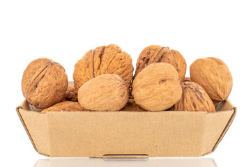 Several ripe delicious walnuts in a paper box, close-up, isolated on white.