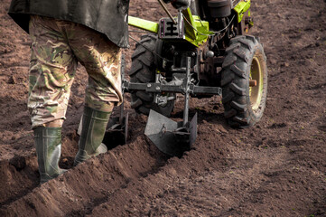 farmer prepares land for planting potatoes with a moto-block. High quality photo