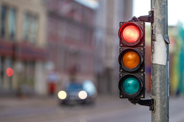 view of city traffic with traffic lights, in the foreground a traffic light with a red light