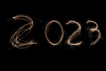 New Year 2023 light. Sparklers draw figures 2023.