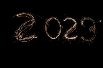 New Year 2023 light. Sparklers draw figures 2023.