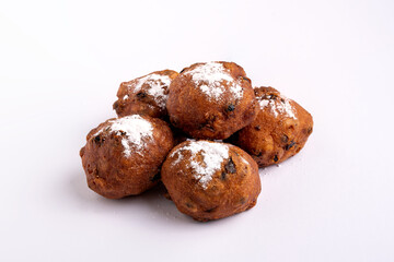 A pile of Dutch traditional oliebollen (dough balls) with powdered sugar isolated on white background