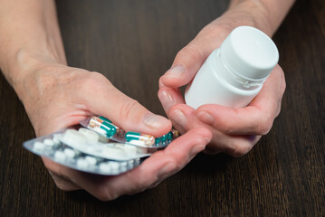 Senior woman holds medicines, pills in her hand. An elderly lady and her hands.
