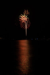 Fireworks bursting and reflecting over the water in Marina del Rey, CA on New Year's Eve