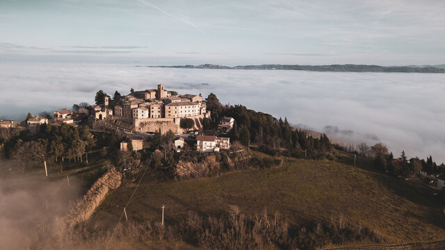 aerial view of the medieval village of Piticchio di Arcevia in the province of Ancona in the Marche region of Italy immersed in the fog