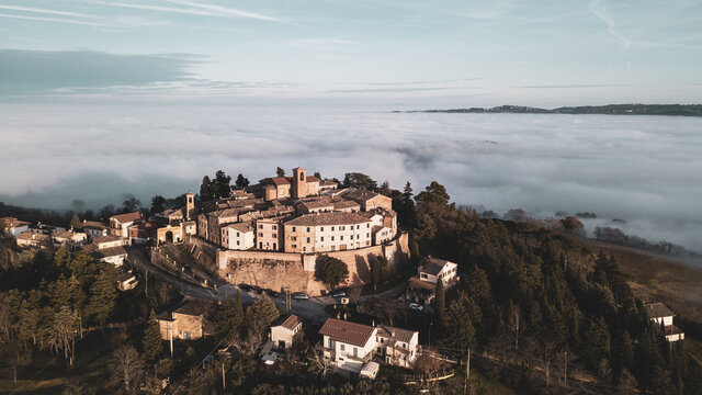 aerial view of the medieval village of Piticchio di Arcevia in the province of Ancona in the Marche region of Italy immersed in the fog
