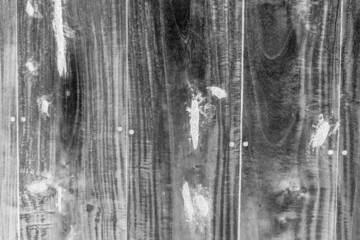 Black and white image of an old wooden board with white repair spots for texture background