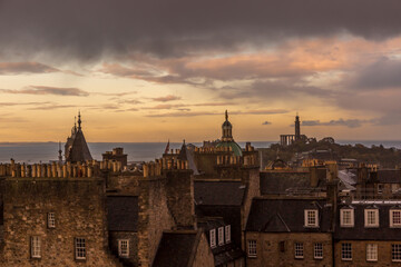 Looking across the Edinburgh rooftops as the sun sets on a cloudy day in Scotland