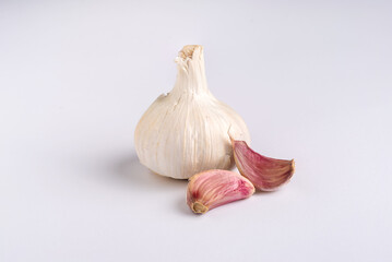 Purple garlic bulb and cloves on white background