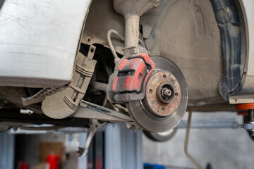 Vehicle's disc brake inspection and maintenance for repair in new tire changing process. Car brake repair in garage. close-up photo