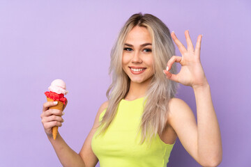 Teenager girl over isolated purple background showing ok sign with fingers