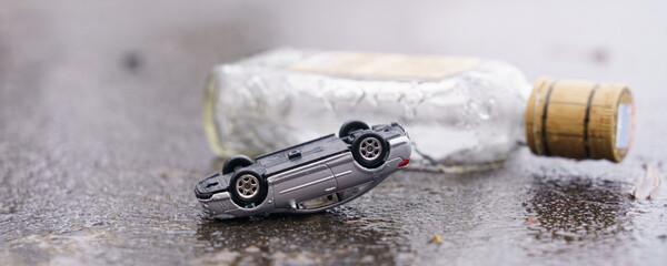 Traffic accident - an overturned car with a bottle of alcohol in the background.