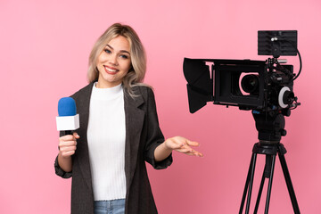 Reporter woman holding a microphone and reporting news over isolated pink background smiling