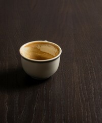 Almost empty dirty coffee mug on dark wooden table