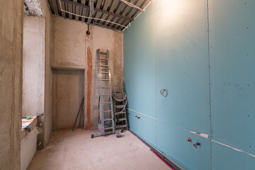 Working process of renovate room with installing drywall or gypsum plasterboard and ladder with...