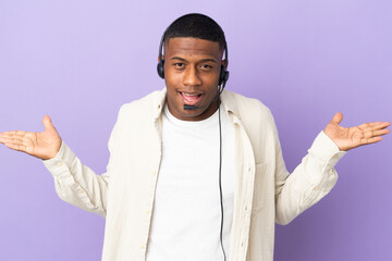 Naklejka premium Telemarketer latin man working with a headset isolated on purple background with shocked facial expression