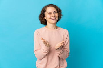 Young English woman isolated on blue background applauding after presentation in a conference