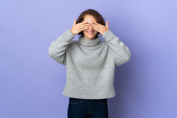 Young English woman isolated on purple background covering eyes by hands and smiling