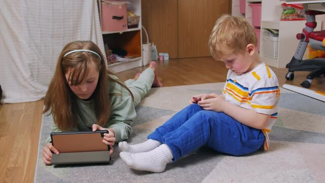 Boy and girl with gadgets at home