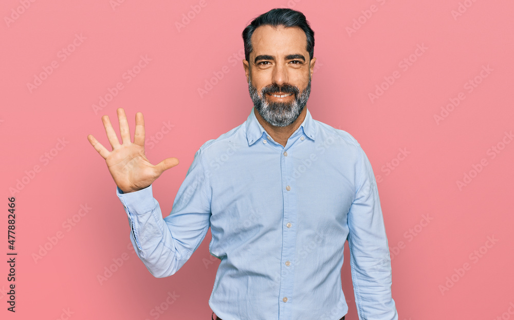 Sticker Middle aged man with beard wearing business shirt showing and pointing up with fingers number five while smiling confident and happy.