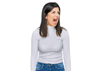 Fototapeta premium Beautiful brunette woman wearing casual clothes angry and mad screaming frustrated and furious, shouting with anger. rage and aggressive concept.