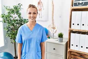 Young caucasian woman working at pain recovery clinic with a happy and cool smile on face. lucky person.