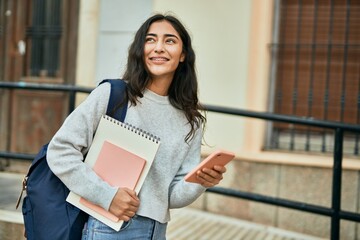 Young middle east student girl smiling happy using smartphone at the city.