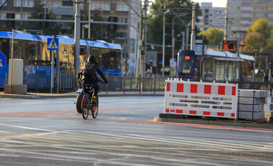 Mężczyzna na rowerze z plecakiem jedzie drogą w mieście, Wrocław.	