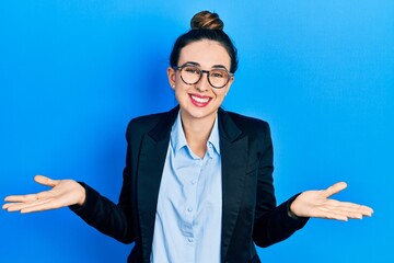Young hispanic girl wearing business clothes and glasses clueless and confused expression with arms...