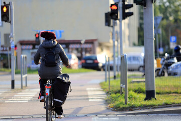 Kobieta na rowerze z plecakiem jedzie ścieżką rowerową w mieście, Wrocław.	