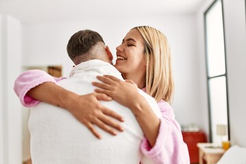 Young caucasian couple smiling happy and hugging standing at bedroom.